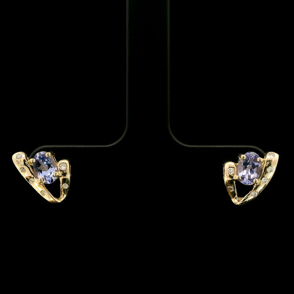 Gold earrings with purple gemstones on a black background